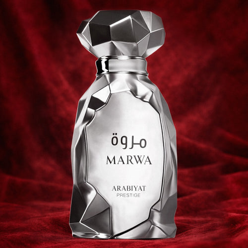 parfumfles van marwa arabiyat prestige. zilver asymmetrisch. op een rode achtergrond.